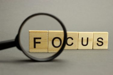 The word focus is made of wooden letters with a magnifying glass